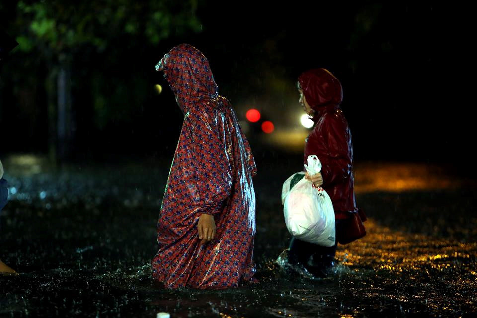 Nhiều người chọn đi bộ thay vì chạy xe qua những vùng nước bị ngập sâu. ẢNH: NGỌC DƯƠNG.