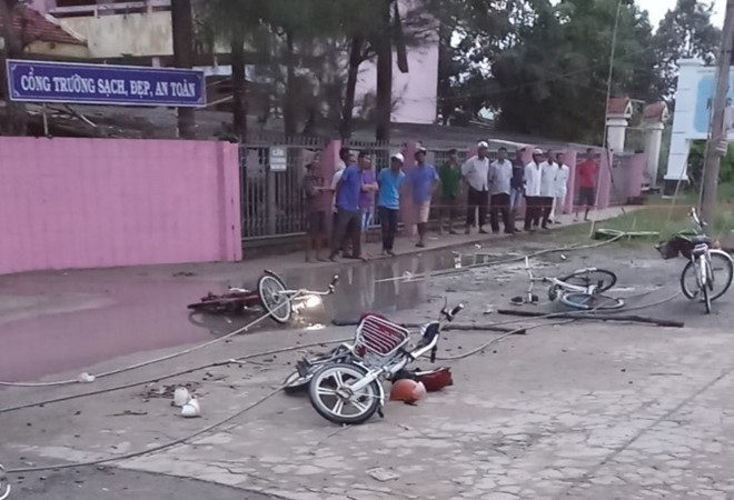 Xe máy các em bị văng nằm trước cổng trường, cạnh dây điện. (Ảnh: Ái Loan)