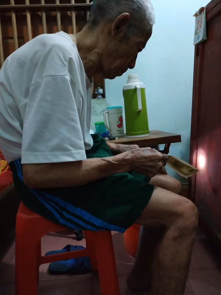 Hình ảnh người ông tay cầm những đồng tiền chuẩn bị đưa cho cháu sau kì nghỉ lễ.