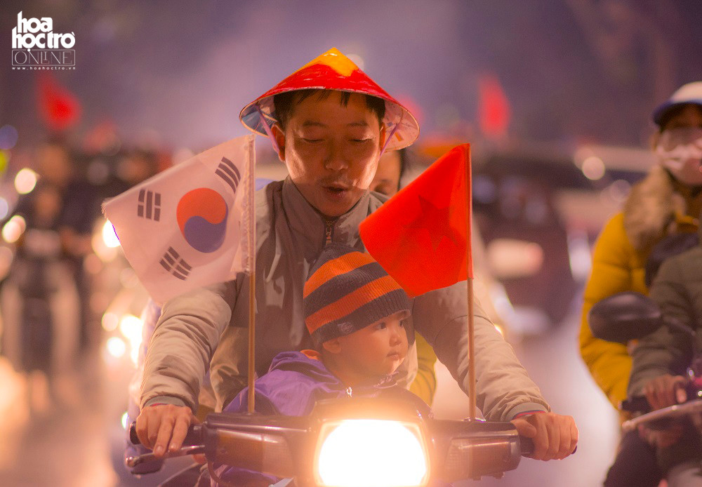 Cổ động viên Việt Nam khi cùng con nhỏ xuống đường ăn mừng chiến thắng nhưng không quên treo cờ của Việt Nam và Hàn Quốc ở 2 bên tay xe