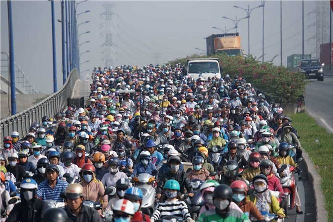 Người và xe xếp hàng dài nối đuôi nhau di chuyển trên đường. (Nguồn ảnh: Tiền Phong)