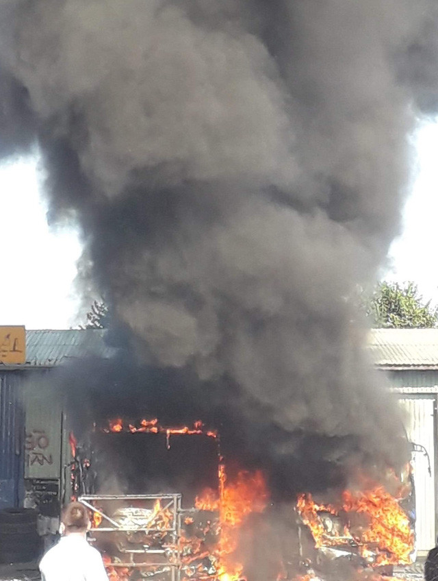 Người dân dùng bình chữa cháy mini nhưng không thể khống chế ngay đám cháy quá lớn.