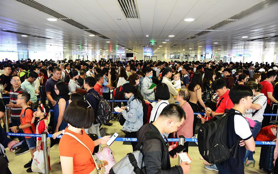 Hàng ngàn hành khách đứng chờ tại khu vực kiểm tra an ninh - khu vực luôn xảy ra tình trạng chật kín người. Nhờ có sự điều phối của lực lượng an ninh, giao thông phía trong sảnh sân bay khá ổn định. (Ảnh: Lê Quân)