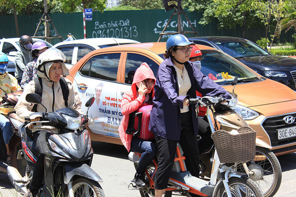 Chờ đèn đỏ ở những đoạn đường vắng bóng cây xanh là một cực hình đối với người sử dụng xe hai bánh.