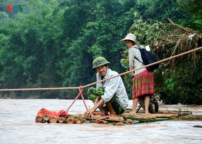 Do mùa lũ, nước suối Nậm Chim lên cao, cuốn trôi cầu tạm bằng tre nên người dân phải dùng bè tre, căng dây thừng qua suối để đi lại.
