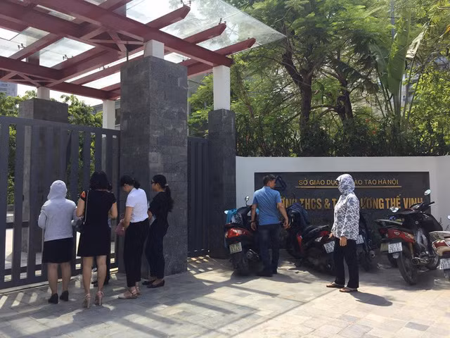 Hình ảnh phụ huynh tụ tập trước cổng trường THCS & THPT Lương Thế Vinh để xin rút hồ sơ và phí đã nộp. Ảnh: Dân Trí.