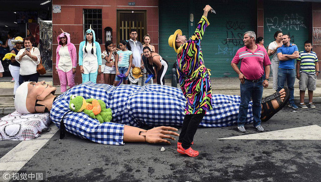 Một du khách chụp hình với hình nộm lớn.