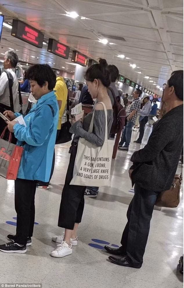 Cô gái với chiếc túi in dòng chữ nguy hiểm.