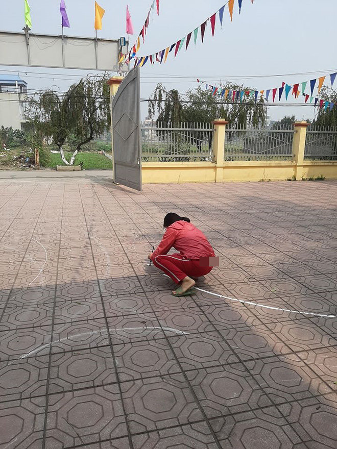 Bố của cô gái (áo xám) đo đạc để vẽ vòng số 8 cho con gái tập lái xe.