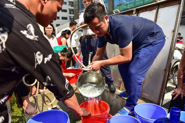 Anh Hoàng nhọc nhằn kéo từng gầu nước.