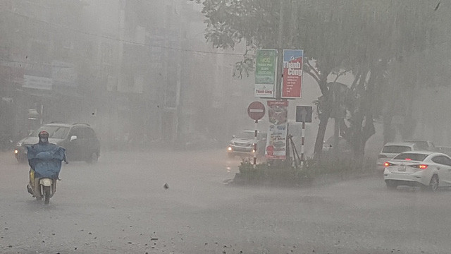 Mưa tiếp tục lớn với những đợt gió mạnh đẩy người đi xe máy xiêu vẹo.