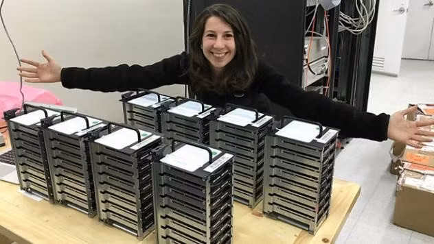 Katie Bouman đang ngồi cạnh 8 chồng ổ chứa dữ liệu dựng hố đen - những “nguyên vật liệu” giúp xác lập hình ảnh hố đen “hot” nhất mạng xã hội những ngày qua.