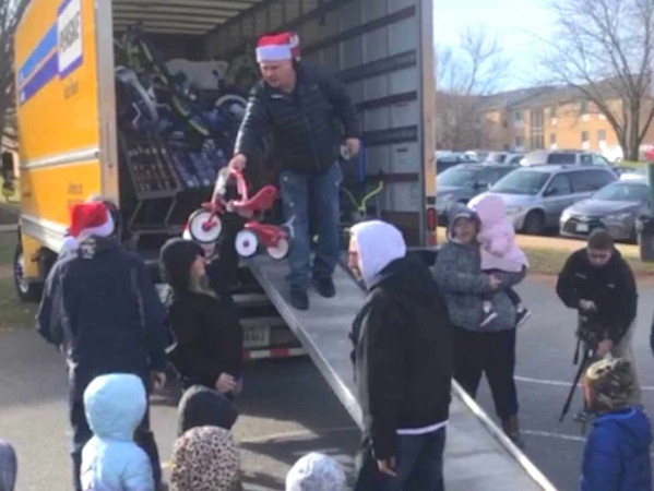 Chú Adam tặng đồ chơi cho trẻ em.