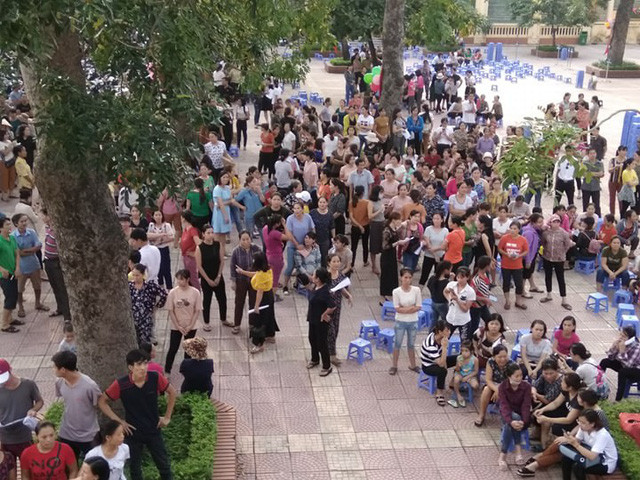 Mặc dù cuộc họp đã tan từ lâu nhưng hàng trăm phụ huynh không ra về, họ nắn lại để yêu cầu hiệu trưởng trả lời cụ thể. Ảnh: Mỹ Hà.