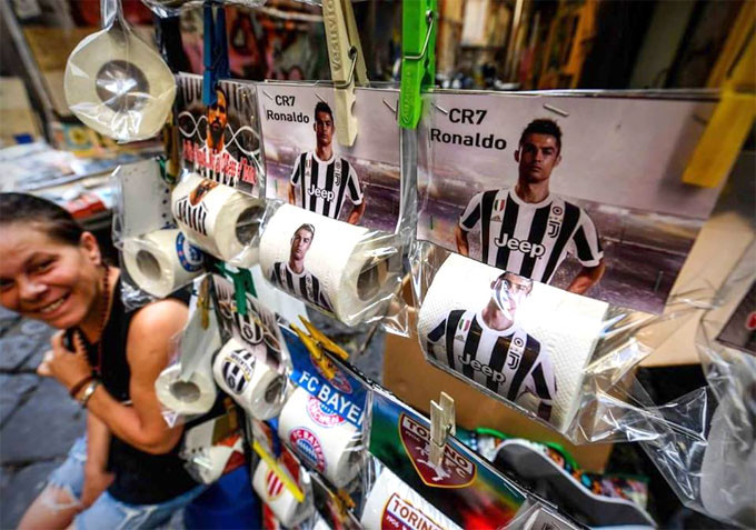Một quầy hàng bày bán rất nhiều giấy vệ sinh có in mặt các cầu thủ là logo của đội bóng.