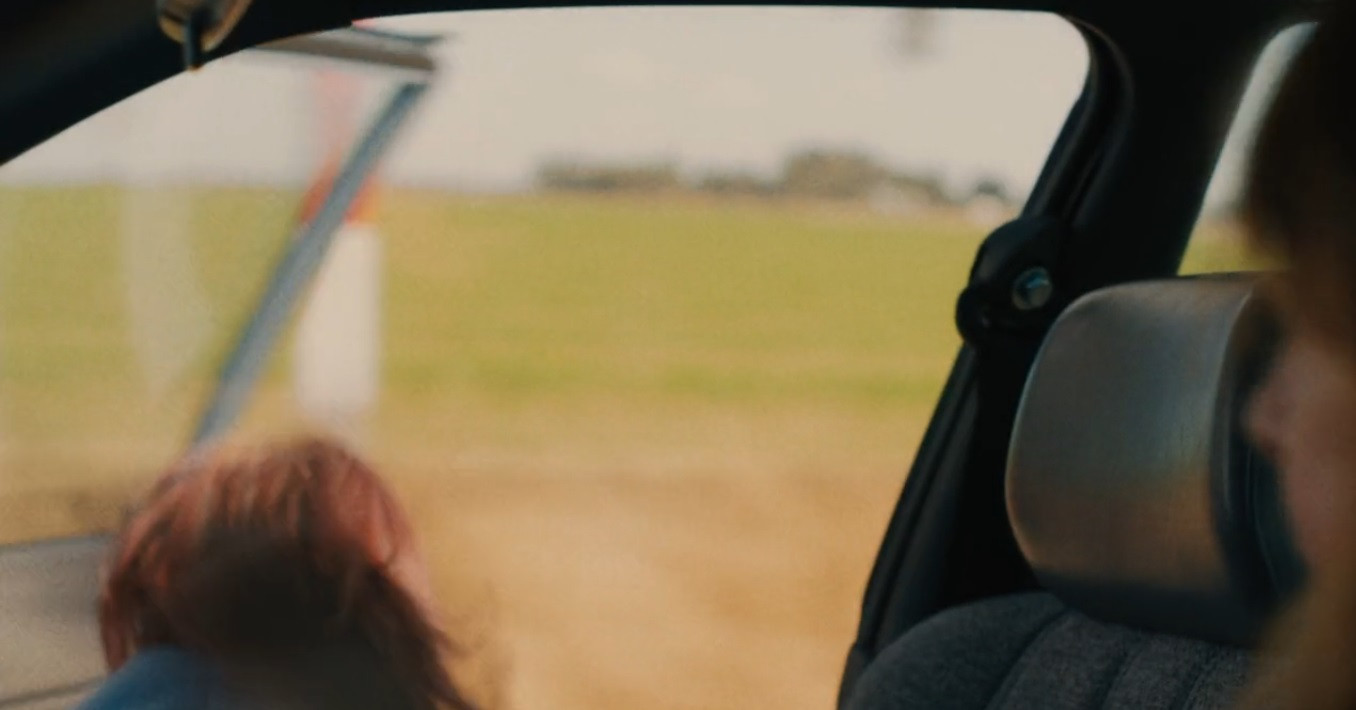 Mặc kệ xe đang chạy, Christine mở cửa xe và lao ra ngoài.