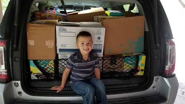 Cậu bé hào hứng khi đóng gói và giao quà cho các bạn.