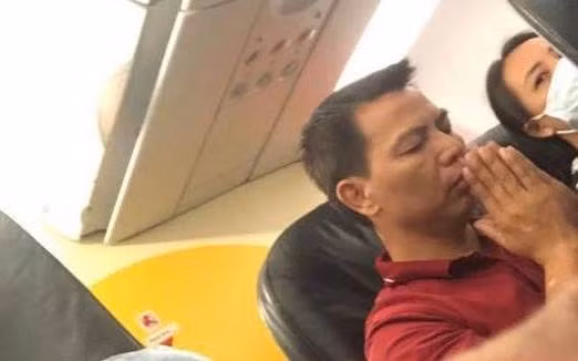 Hành khách trên chuyến bay chắp tay cầu nguyện. (Ảnh: ZING NEWS)