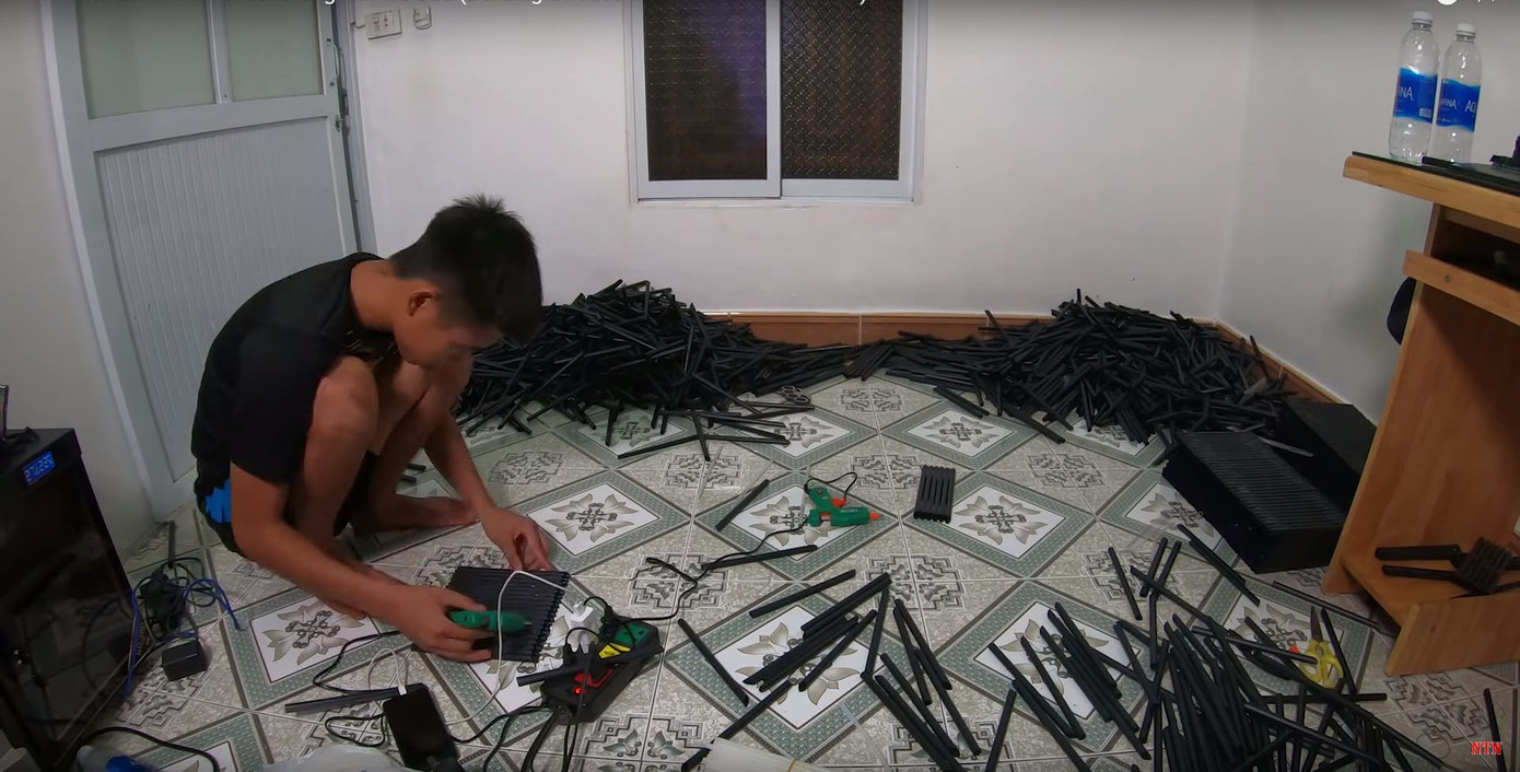 NTN cùng bạn bè dán 5.000 chiếc ống hút nhựa thành từng tấm bằng keo nến. (Ảnh cắt từ clip)