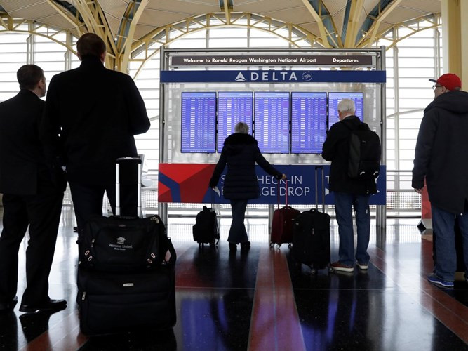 Hành khách theo dõi thông tin chuyến bay tại sân bay quốc gia Ronald Reagan ở Washington.