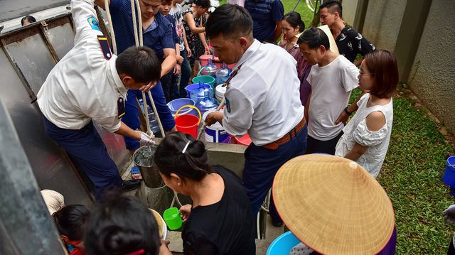 Nhân viên tòa nhà và nhiều thanh niên phải cật lực kéo nước.