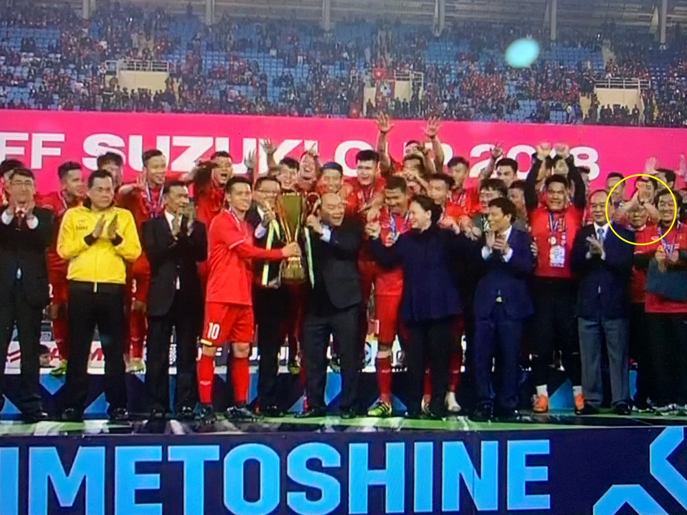HLV Park Hang-seo nép về một góc khi Văn Quyết giương cao chiếc cúp vô địch.