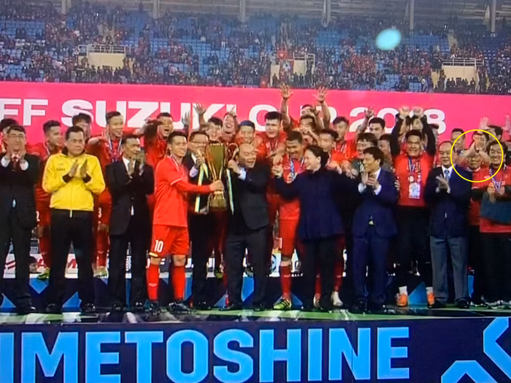 HLV Park Hang-seo nép về một góc khi Văn Quyết giương cao chiếc cúp vô địch.