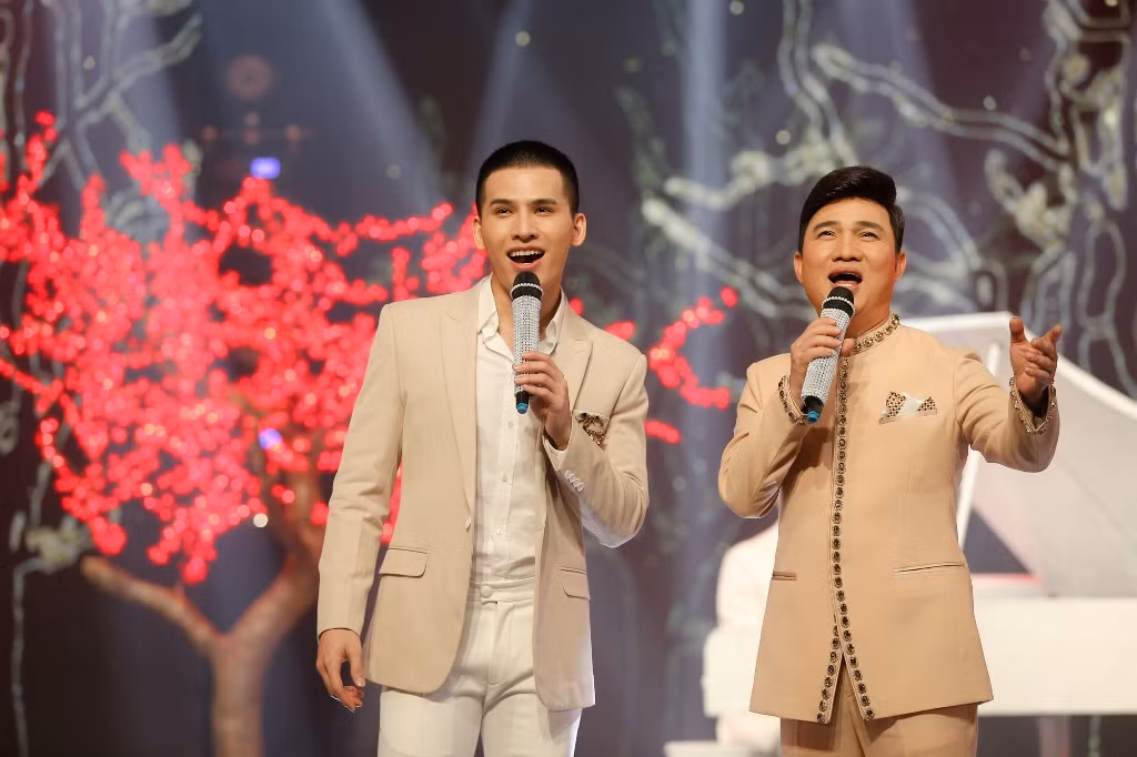 Quốc Thiên kết hợp cùng Quang Linh mang đến không gian âm nhạc sang trọng, nghệ thuật được dàn dựng đẹp mắt với cảnh trí cây hoa rực rỡ trong ca khúc Cười trong năm mới.