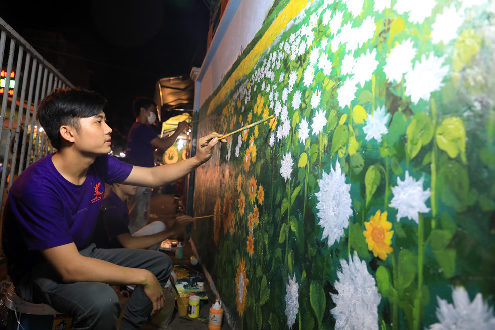 Bức tường dọc lối vào chợ hoa Hồ Thị Kỷ (từ hướng đường Lý Thái Tổ về chợ hoa Hồ Thị Kỷ) được nhân viên cho “mặc áo mới” bằng những bức tường hoa nhìn rất đẹp mắt ẢNH: LAM NGỌC