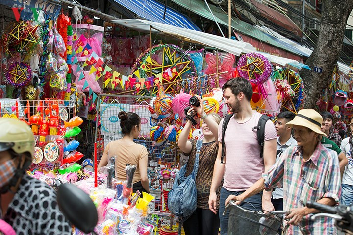 Du khách nước ngoài hòa vào dòng người dạo chợ Trung thu.