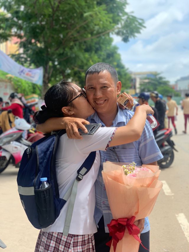 Nụ hôn ngọt ngào của con dành cho bố sau khi hoàn thành kỳ thi. Ảnh:Hữu Phúc.