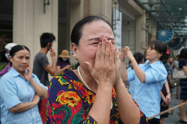 Một phụ nữ bật khóc khi đoàn xe chở lĩnh cữu Chủ tịch nước đi qua các con phố ở khu vực Nhà hát Lớn. (Ảnh: Quân Đỗ).