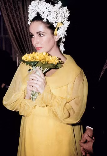 Trong đám cưới lần thứ 5, Elizabeth Taylor đã diện chiếc váy cưới dáng suông đơn giản nhưng tinh tế với điểm nhấn trên váy là phần cổ và tay áo điệu đà. Chiếc váy của thương hiệu Gina Fratini này có giá 62.500 USD (khoảng 1,5 tỷ VNĐ).