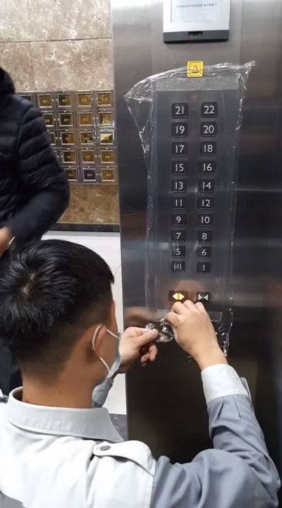 Ban quản lý chung cư 170 Đê La Thành triển khai việc bọc nilon cho nút bấm của thang máy và sẽ thay hàng ngày để giảm thiểu nguy cơ có thể lây nhiễm dịch bệnh.