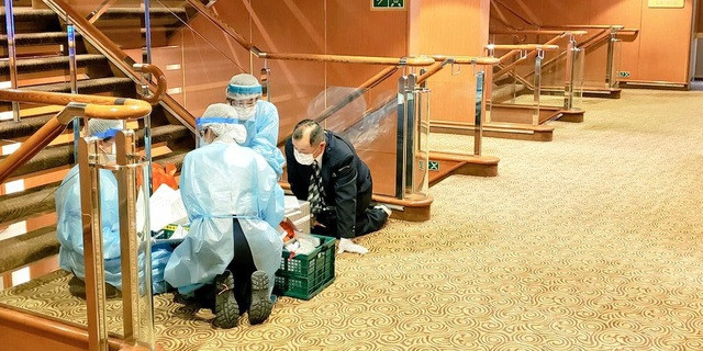 Các nhân viên y tế mặc đồ bảo hộ làm việc trên tàu Diamond Princess. Ảnh: Twitter.