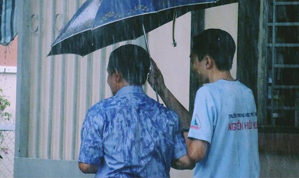 Sau khi con vào phòng thi, ông bố vẫn đứng nhìn theo rất lâu. (Ảnh: FB Sài Gòn của tôi)