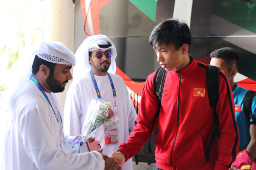 Văn Hậu và các cầu thủ Việt Nam nhận hoa, quà và nhận chìa khóa phòng từ đội tiền trạm VFF dẫn đầu bởi phó phòng đội tuyển Đoàn Anh Tuấn. Ảnh: NGỌC LINH.