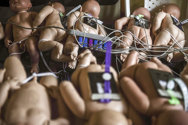 "Trẻ sơ sinh" robot giáo dục giới tính được sạc pin tại trường. Ảnh: AFP.