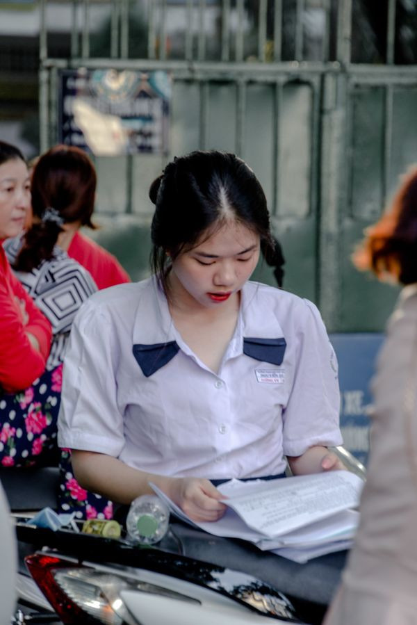 Thí sinh nữ tại điểm thi THPT Nguyễn Khuyến (quận 10, TP.HCM) tranh thủ ôn bài trước khi bước vào phòng thi.