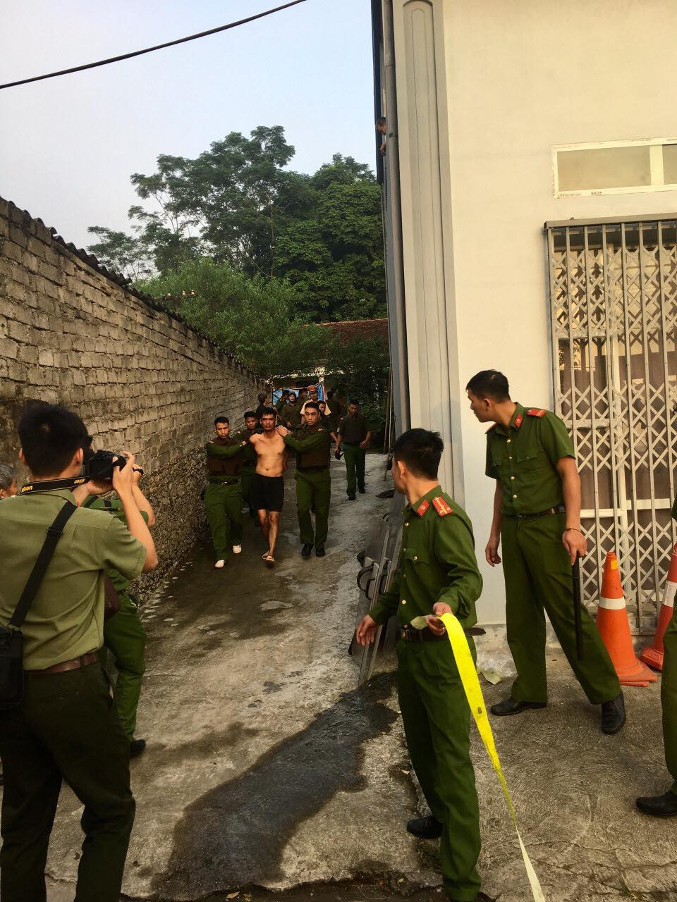 Lực lượng công an áp giải nghi phạm. Ảnh: Huyền Chinh