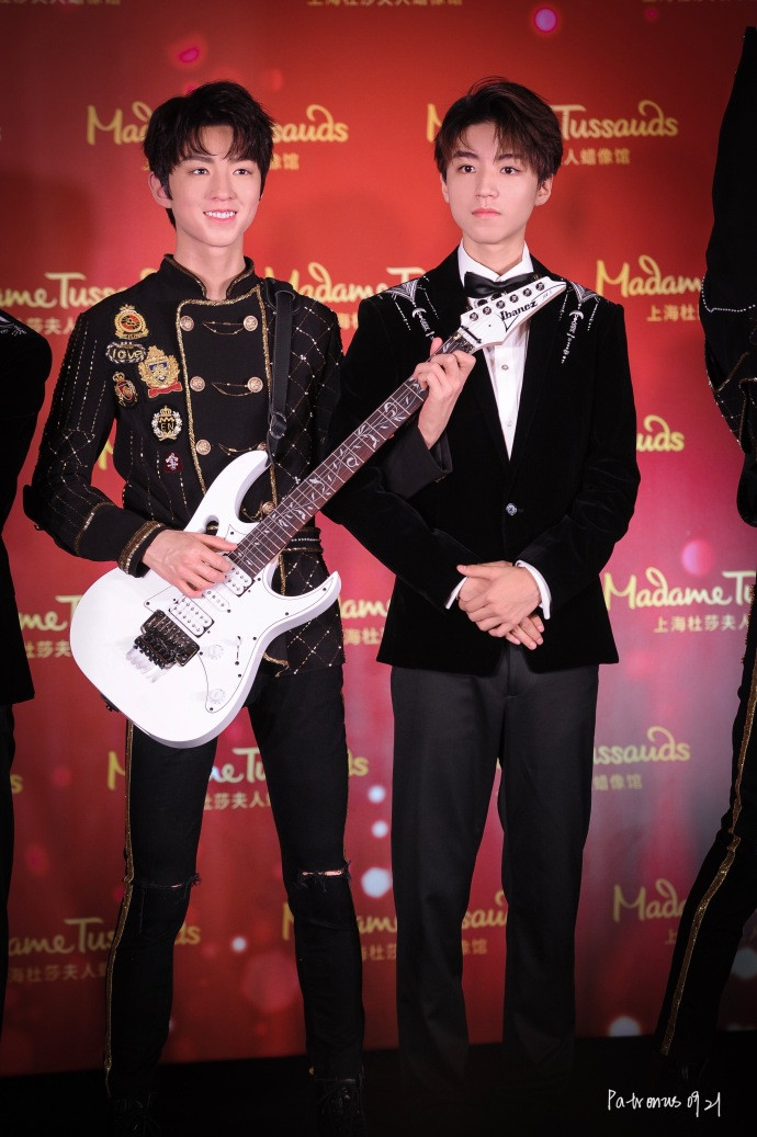 Vương Tuấn Khải đứng cạnh tượng sáp của mình, với chiếc đàn ghita biểu tượng.