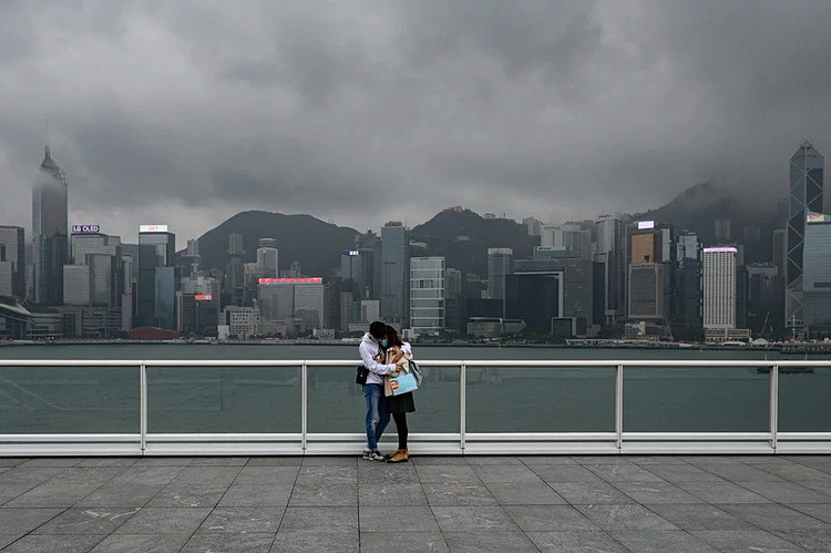 Một cặp đôi đeo khẩu trang ôm nhau trên bờ sông tại Tsim Sha Tsui, Hong Kong. Ảnh: AFP.