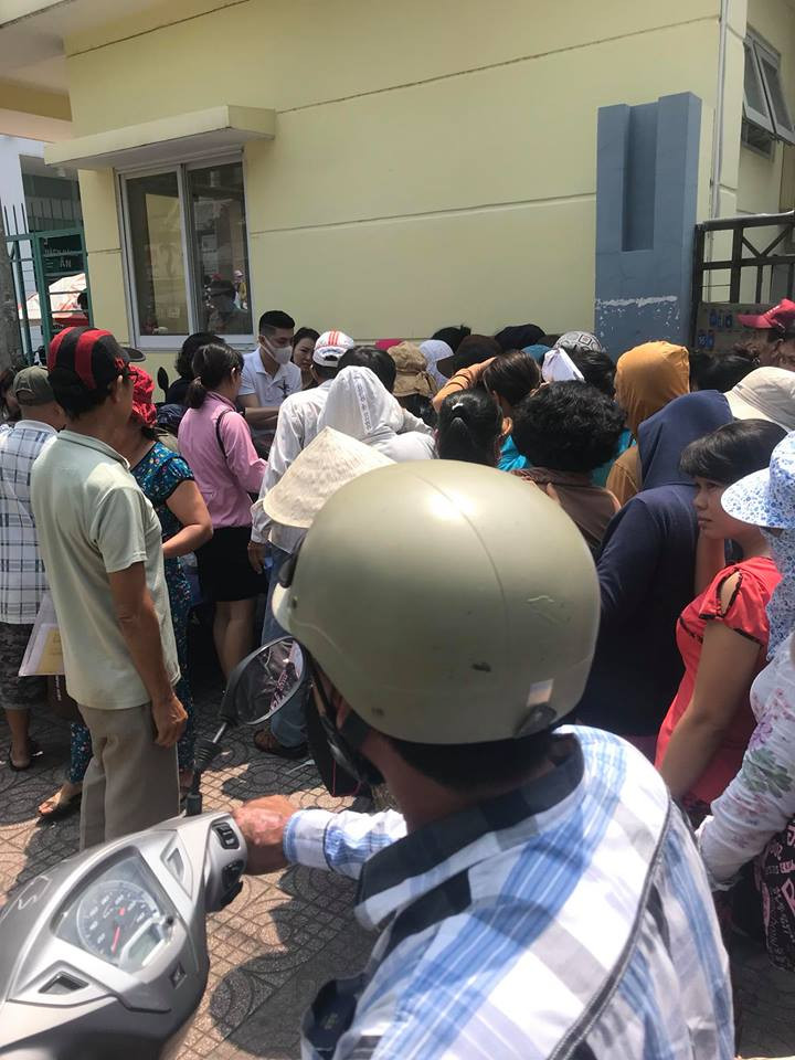 Đông đảo người dân đứng xếp hàng chờ cơm do anh phát.