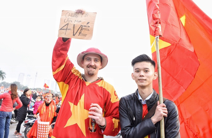 Một CĐV nước ngoài mặc nguyên cây đồ cờ đỏ sao vàng hòa vào dòng người Việt Nam. Một CĐV nước ngoài mặc nguyên cây đồ cờ đỏ sao vàng hòa vào dòng người Việt Nam.