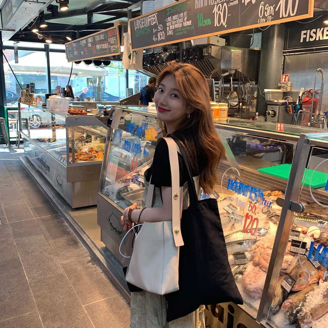 Trong khi thiên hạ đi châu Âu sẽ đầu tư váy áo thật lộng lẫy, váy nọ mũ kia thì Suzy đơn giản đến mức xuề xòa, một vai khoác hai túi, tay ôm áo khoác cũng chẳng thấy vấn đề gì.