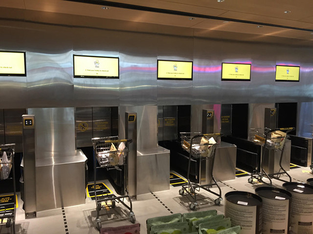 Người mua dừng xe đẩy trước hệ thống tự động kiểm tra và đợi nhận hàng từ robot.