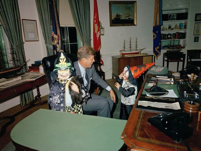 Tổng thống John F. Kennedy mỉm cười khi hai người con của ông là Caroline Kennedy và John F. Kennedy Jr khoe cha những bộ trang phục Halloween trong Phòng Bầu Dục ngày 31/10/1963.