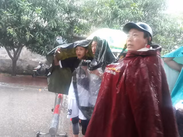 Nhiều người dân vẫn đội mưa theo dõi vụ việc từ xa.