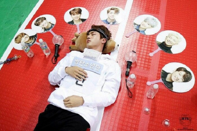 Jin (BTS) ngủ say sưa như đang ở nhà vậy đó, lại còn được các thành viên khác trang trí xung quanh rõ là có tâm luôn.