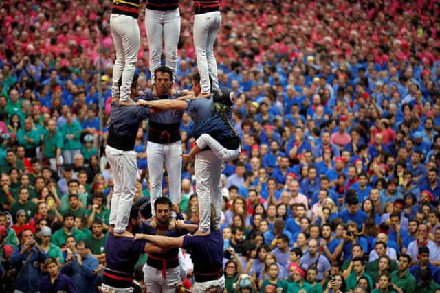Mỗi đội chơi sẽ mặc đồng phục với màu áo riêng. Các thành viên trong đội sẽ trèo lên vai nhau để đứng và giữ thăng bằng. Ảnh: Reuters.